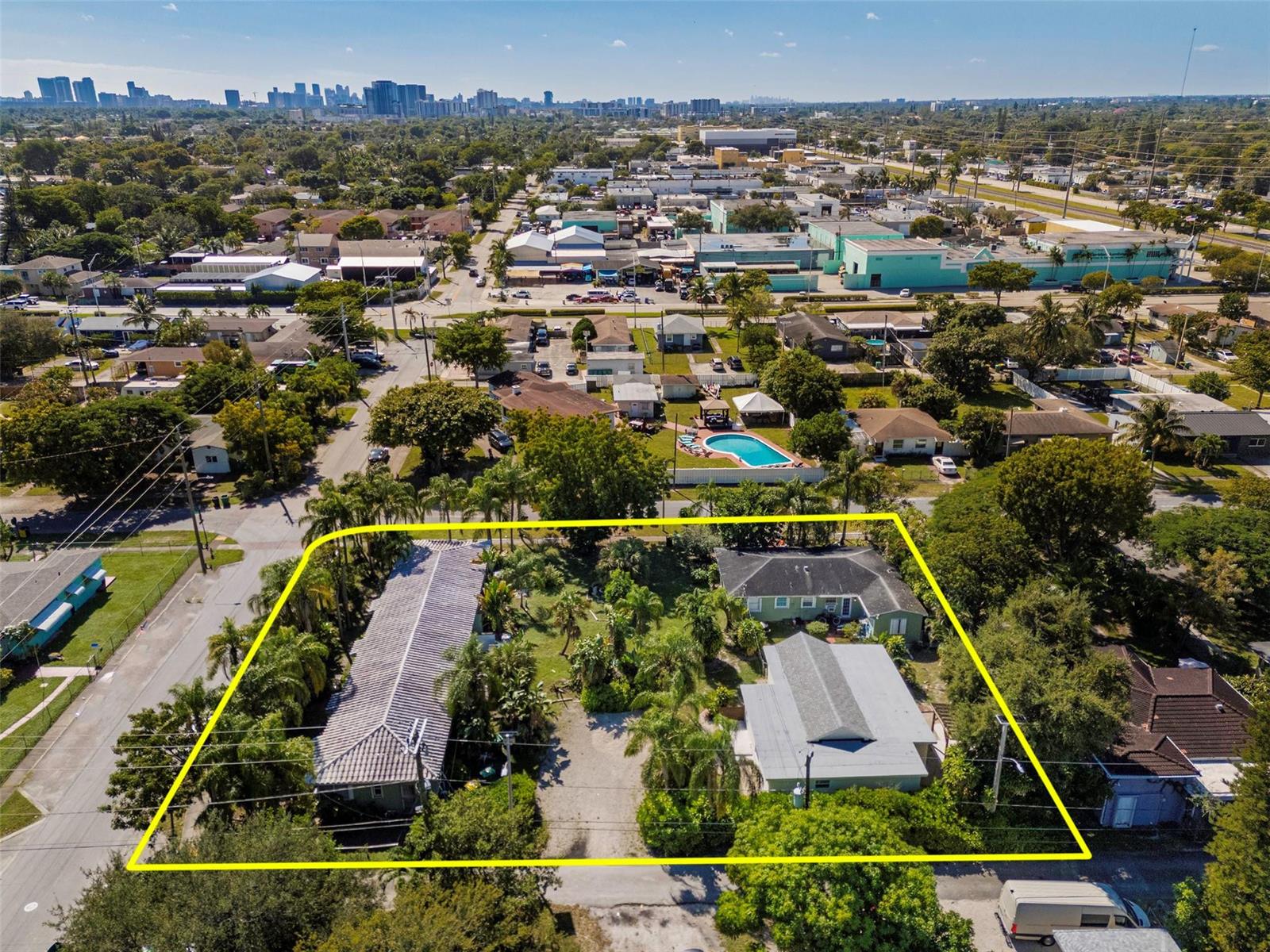 An aerial view shows a residential lot with three buildings, lush landscaping, and a driveway — 302 SW 15th Street, Dania Beach FL 33004, DANIA BEACH, FL
