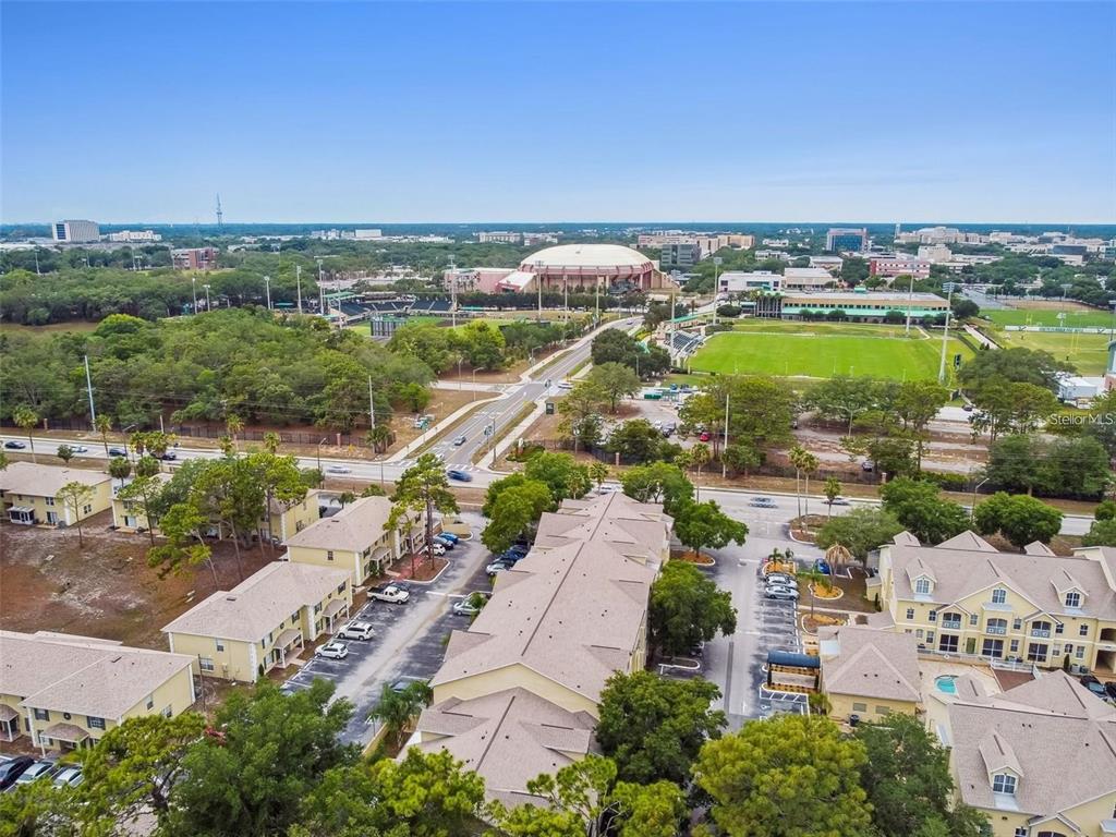 An aerial view shows a residential apartment complex near a large stadium and sports fields — 5154 SUNRIDGE PALMS DRIVE UNIT 5154, TAMPA, FL