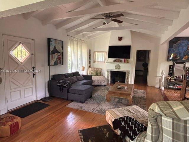 A living room features a vaulted ceiling, hardwood floors, a fireplace, and a sectional sofa — 8228 NE 8th Ct, Miami FL 33138, MIAMI, FL