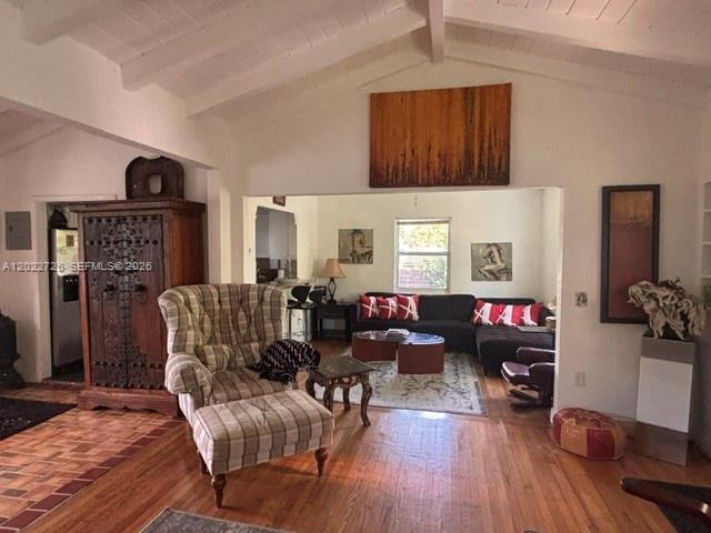 A living room features a vaulted ceiling, hardwood floors, and a large wooden armoire — 8228 NE 8th Ct, Miami FL 33138, MIAMI, FL