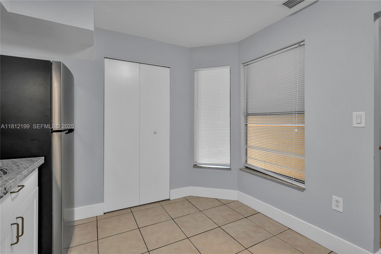 A kitchen corner features light gray walls, tile flooring, a stainless refrigerator, and two windows — 8109 SW 21 CT # 8109, Miramar FL 33025, MIRAMAR, FL