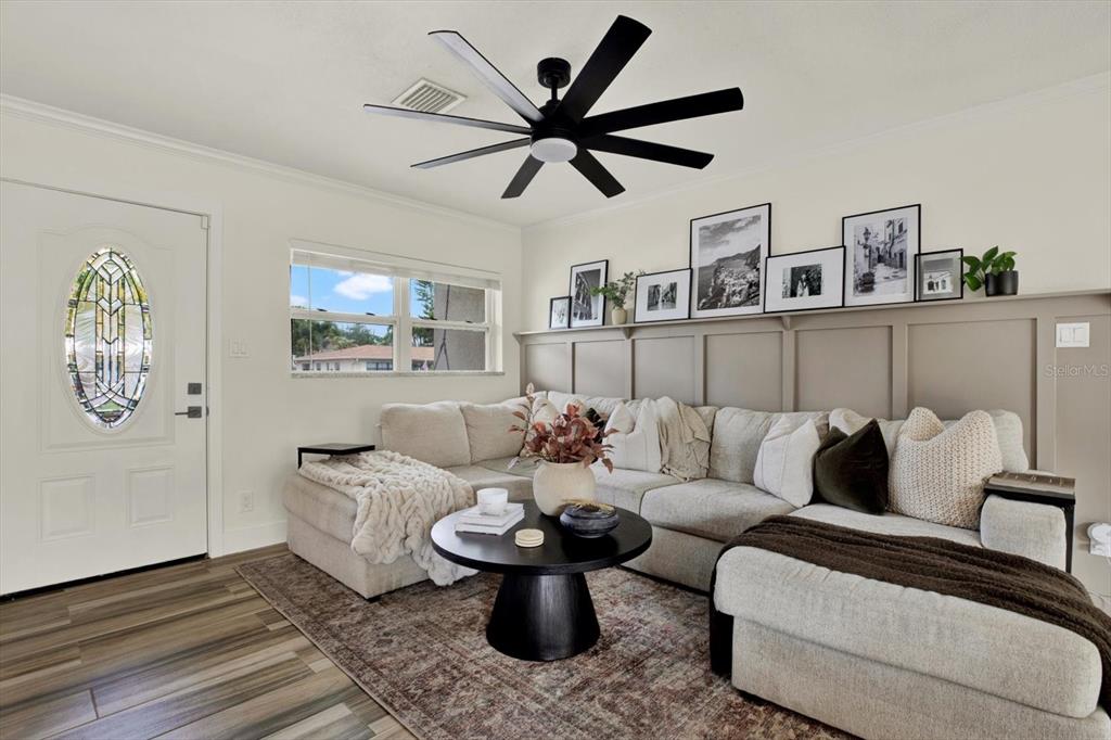A living room features a sectional sofa, a round coffee table, and a picture ledge — 1308 MARION DRIVE S, ST PETERSBURG, FL