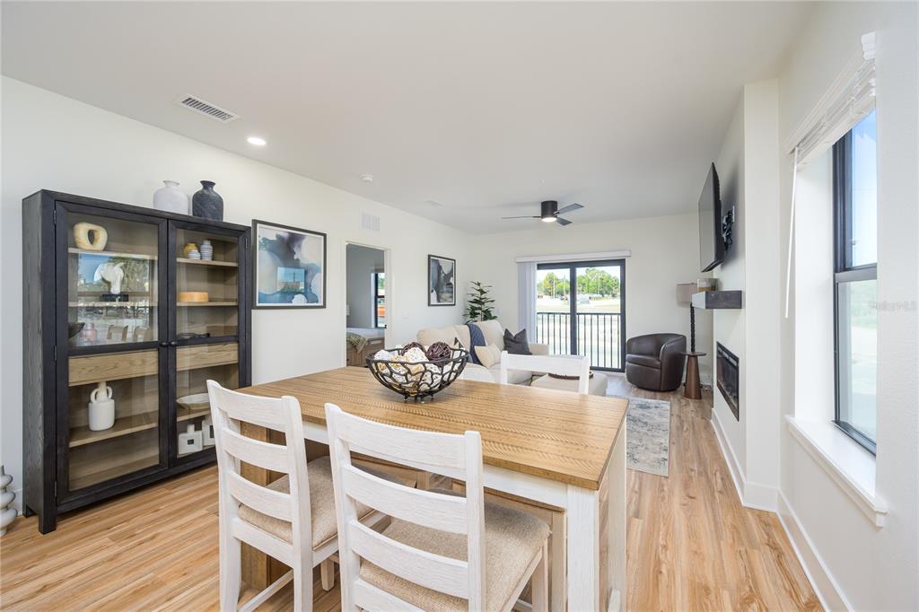 A dining area with a wooden table and chairs sits in front of a living room — 415 SE 1ST AVENUE UNIT 103, OCALA, FL