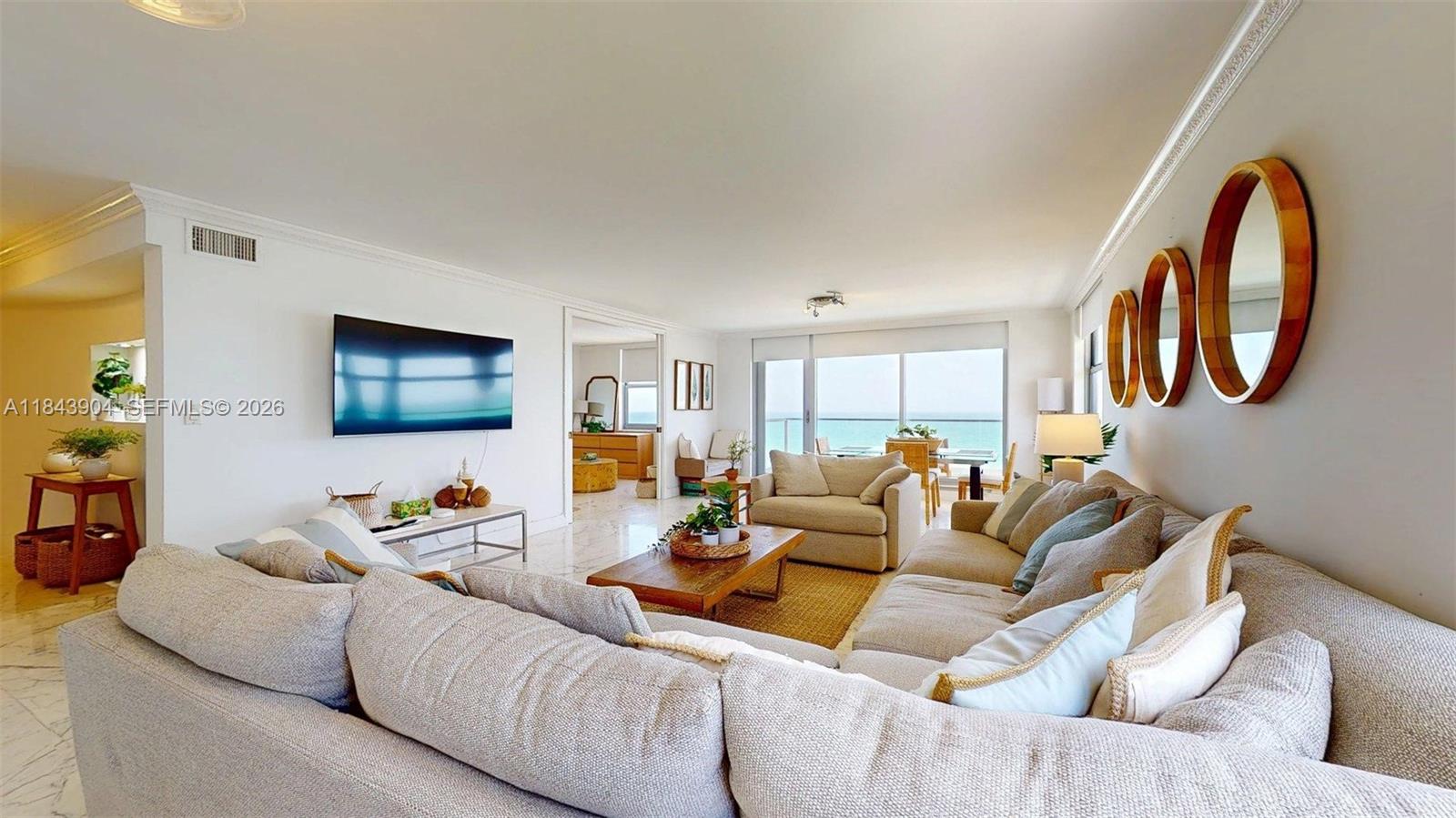 A living room features a large sectional sofa, a television, and a balcony with ocean views — 1912 S Ocean Dr # 9A, Hallandale Beach FL 33009, HALLANDALE BEACH, FL