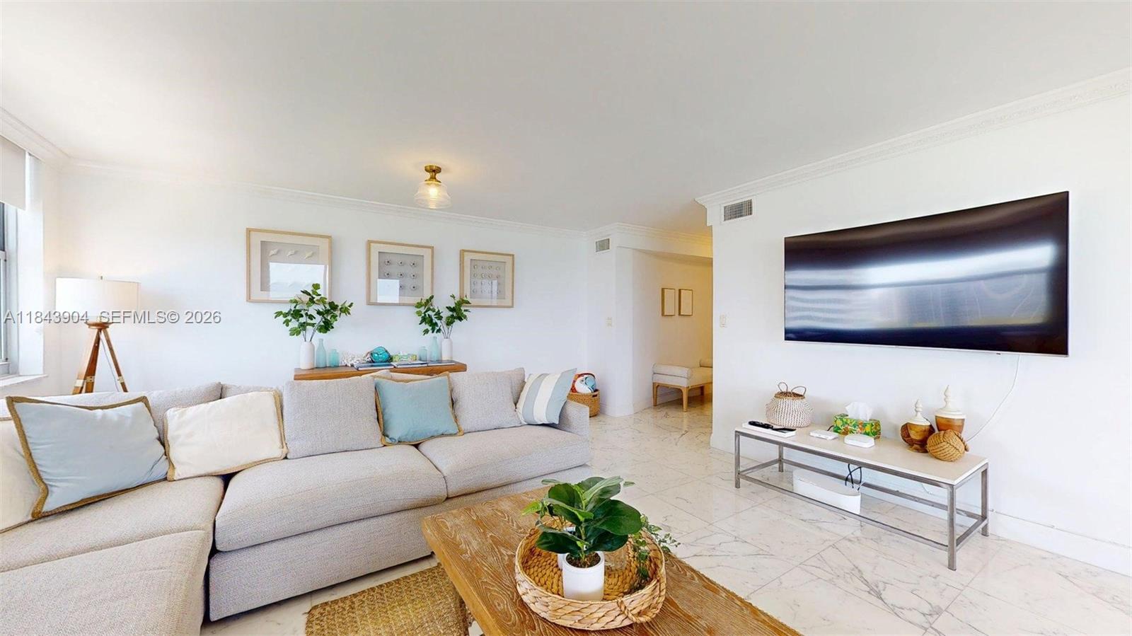 A living room features a gray sectional sofa, a television, and white marble flooring — 1912 S Ocean Dr # 9A, Hallandale Beach FL 33009, HALLANDALE BEACH, FL