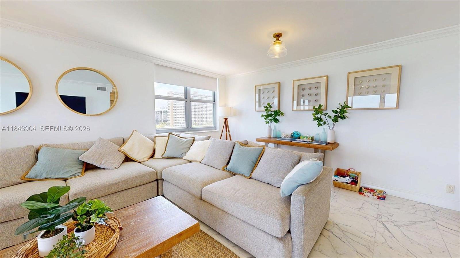 A living room features a large sectional sofa, marble floors, and a wooden coffee table — 1912 S Ocean Dr # 9A, Hallandale Beach FL 33009, HALLANDALE BEACH, FL