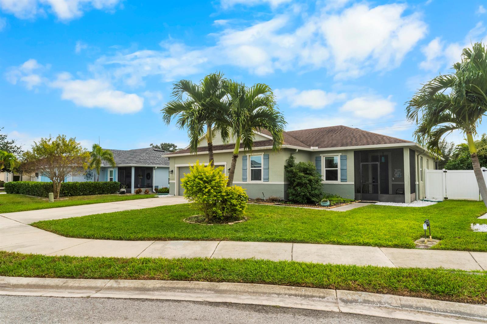 A single-story house with a green exterior, palm trees, and a screened-in porch — 110 65th Avenue E, Bradenton FL 34203, BRADENTON, FL