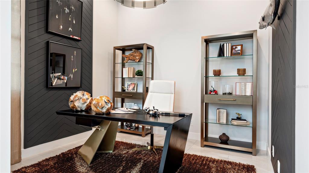 A home office features a dark desk, two glass-shelved bookcases, and black chevron-patterned accent walls — 1230 TRIDENT LOOP, DELAND, FL
