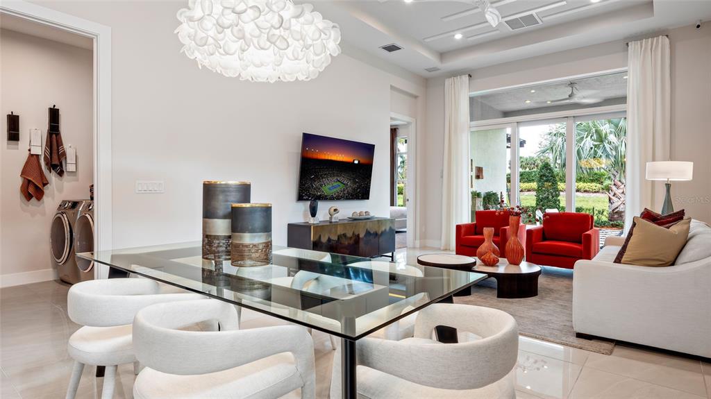 A dining area with a glass table and white chairs opens into a living room — 1230 TRIDENT LOOP, DELAND, FL