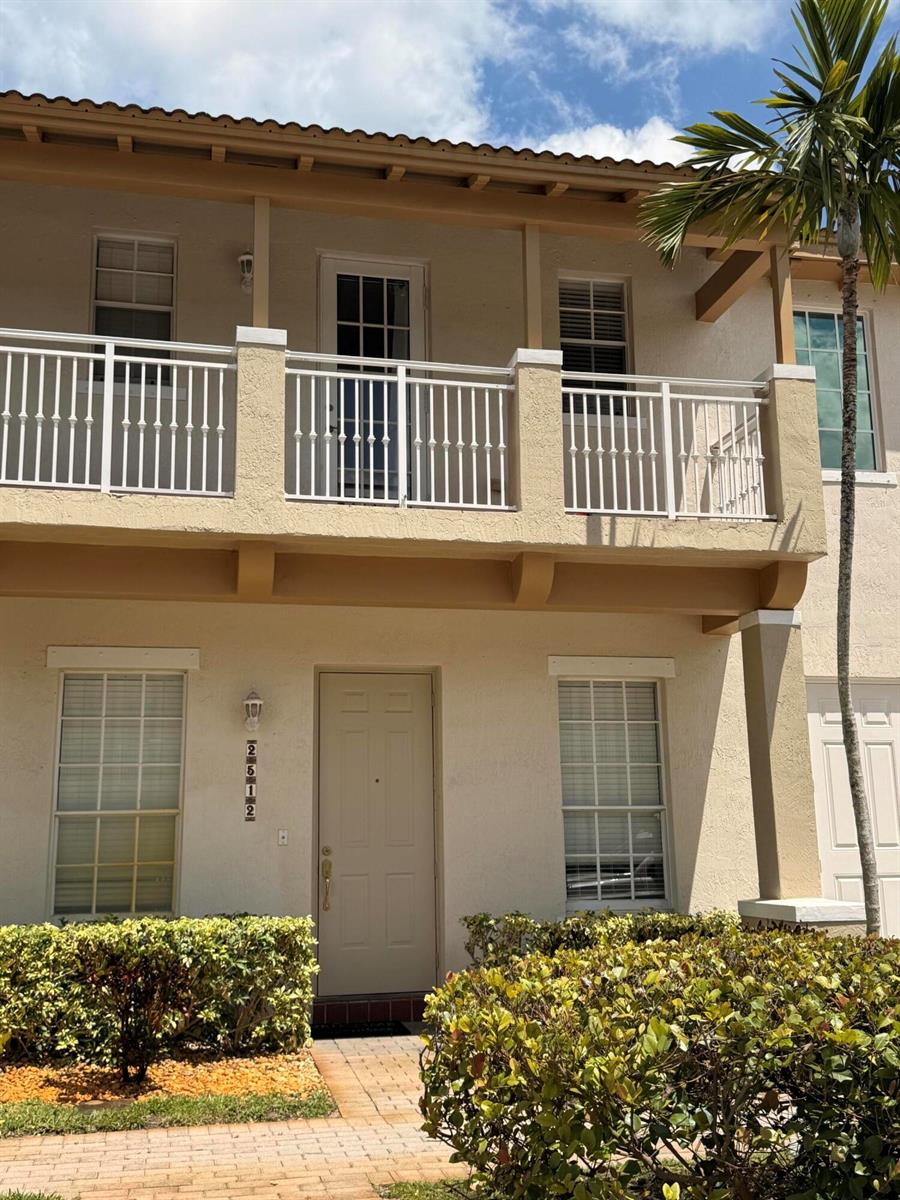 A two-story stucco building features a second-floor balcony with white railings and a front entrance — 2512 NW 4th Street, Boynton Beach FL 33426, BOYNTON BEACH, FL