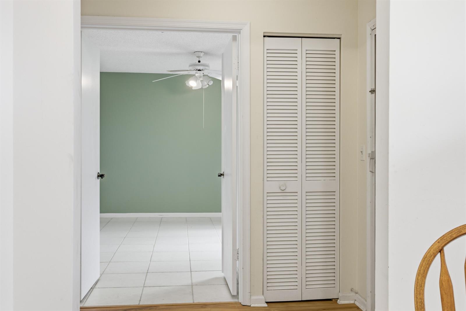 A doorway leads from a hallway with a louvered closet into a room with green walls — 10118 Mangrove Drive # 105, Boynton Beach FL 33437, BOYNTON BEACH, FL