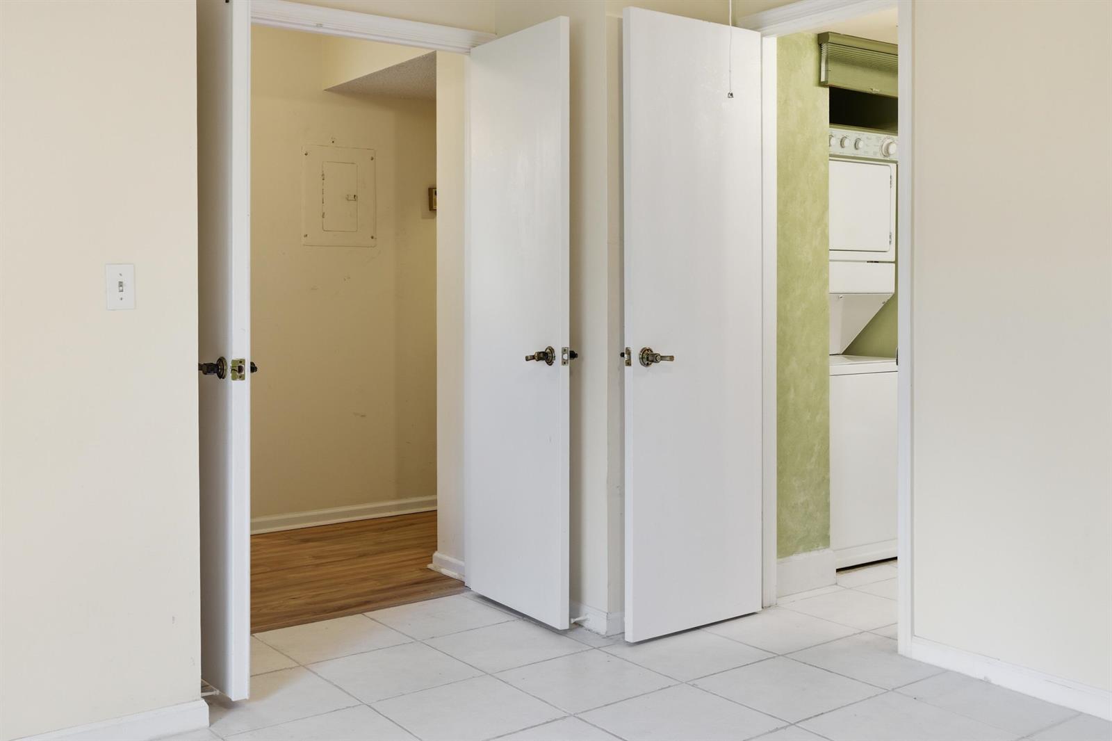 A tiled room features two open white doors leading to a closet and laundry area — 10118 Mangrove Drive # 105, Boynton Beach FL 33437, BOYNTON BEACH, FL