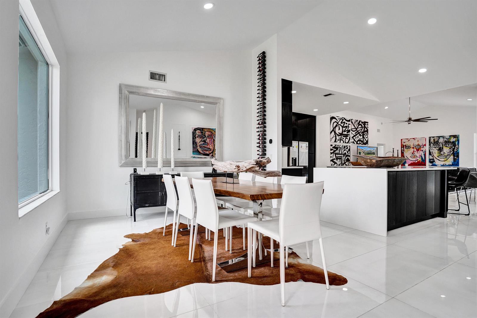 A dining room with white chairs, a wooden table, a cowhide rug, and modern art — 4300 Hunting Trail, Lake Worth FL 33467, LAKE WORTH, FL