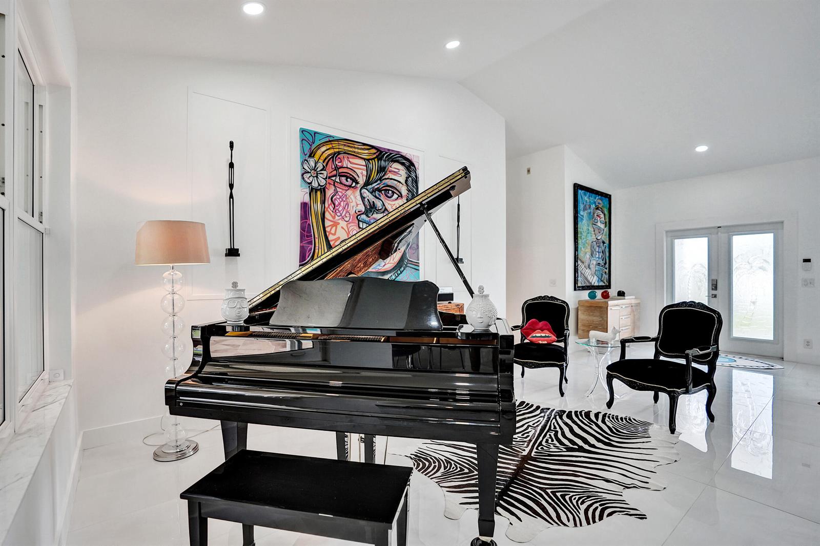 A grand piano sits in a white living room featuring a zebra-print rug and artwork — 4300 Hunting Trail, Lake Worth FL 33467, LAKE WORTH, FL