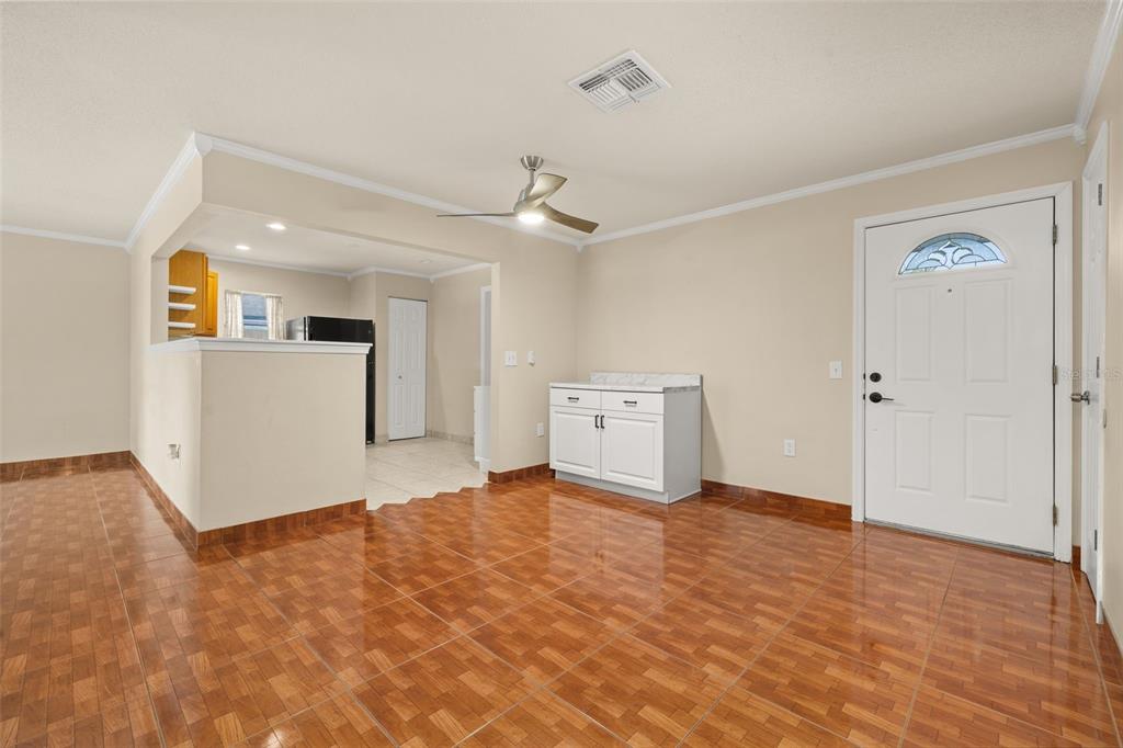 An interior view of a room with brown tiled flooring, a white cabinet, and a door — 235 TENNESSEE AVENUE, ST CLOUD, FL