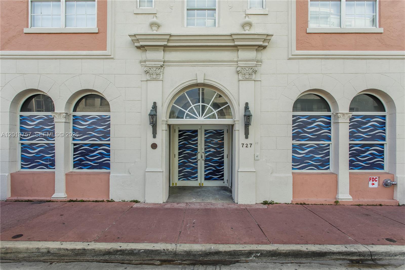 The exterior of a building features a central arched entrance with decorative columns and windows — 727 Collins Ave, Miami Beach FL 33139, MIAMI BEACH, FL