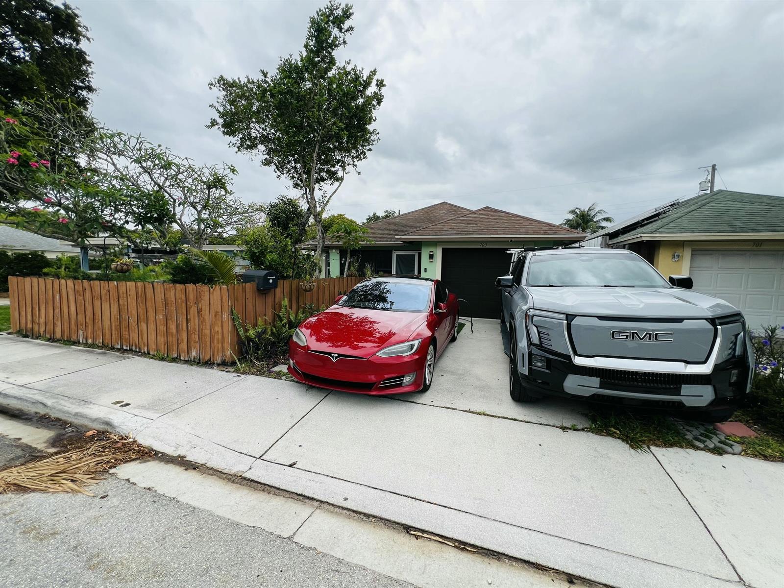 A red Tesla and a gray GMC truck are parked in the driveway of a house — 703 S A Street S, FL 33460, FL