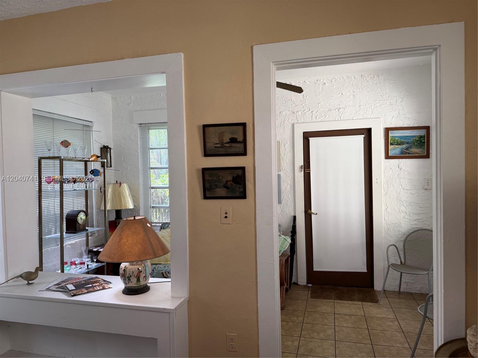 An interior view shows a doorway and a pass-through window between two rooms — 1209 Aguila Ave, Coral Gables FL 33134, CORAL GABLES, FL