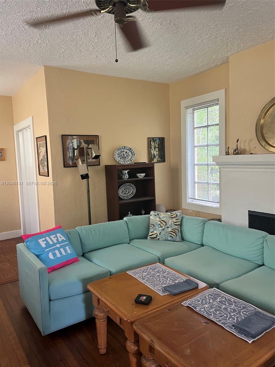 A living room features a light blue sectional sofa, a wooden coffee table, and a fireplace — 1209 Aguila Ave, Coral Gables FL 33134, CORAL GABLES, FL