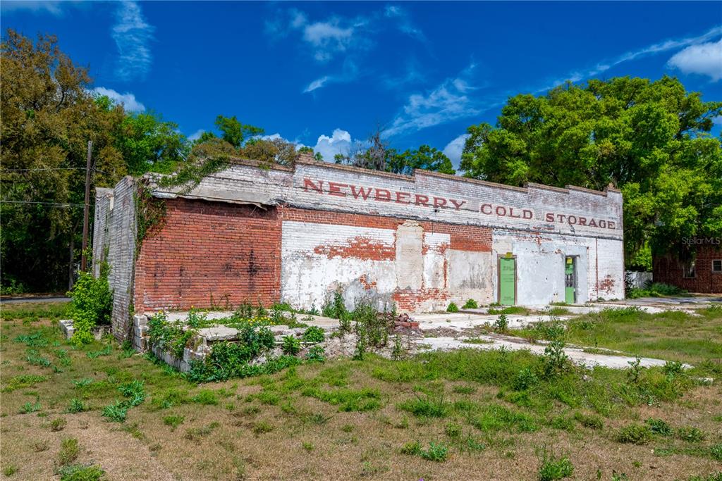 A weathered brick building with the words Newberry Cold Storage painted on the exterior wall — 98 NW 254TH STREET, NEWBERRY, FL