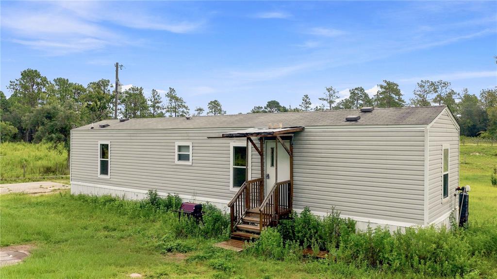 An empty room with tan paneled walls, light wood-look flooring, and a ceiling fan — 3342 SW 166TH COURT ROAD, OCALA, FL