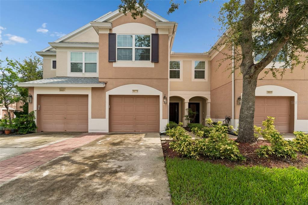 A bedroom features a gray upholstered headboard, a dark green bedspread, and a potted plant — 26523 CHIMNEY SPIRE LANE, WESLEY CHAPEL, FL
