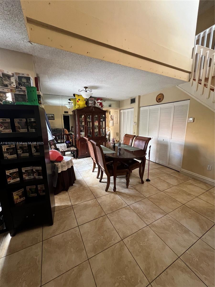 A dining area features a wooden table, chairs, a hutch, and tiled flooring — 4900 SW 149th Ct # 12C, Miami FL 33185, MIAMI, FL