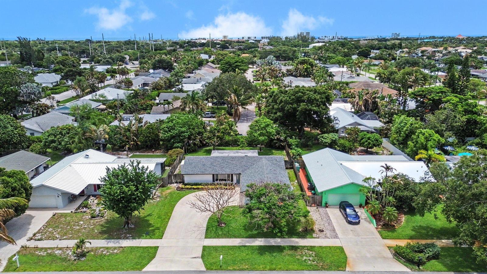 An aerial view shows three single-story houses with driveways and lawns in a suburban neighborhood — 126 Chapel Lane, Tequesta FL 33469, TEQUESTA, FL