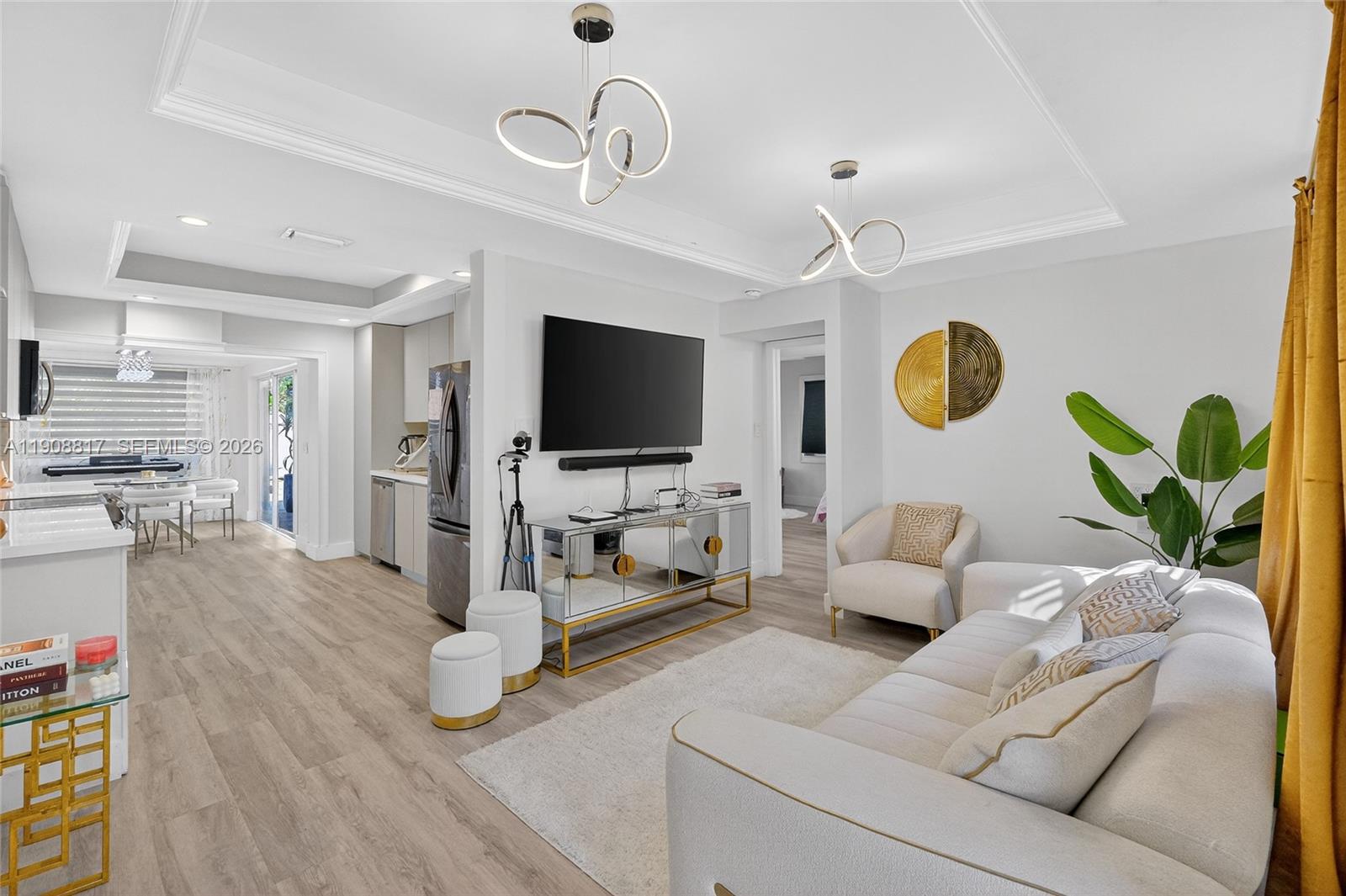 A modern living room features a white sofa, mirrored media console, and two sculptural light fixtures — 155 NW 124th St, North Miami FL 33168, NORTH MIAMI, FL