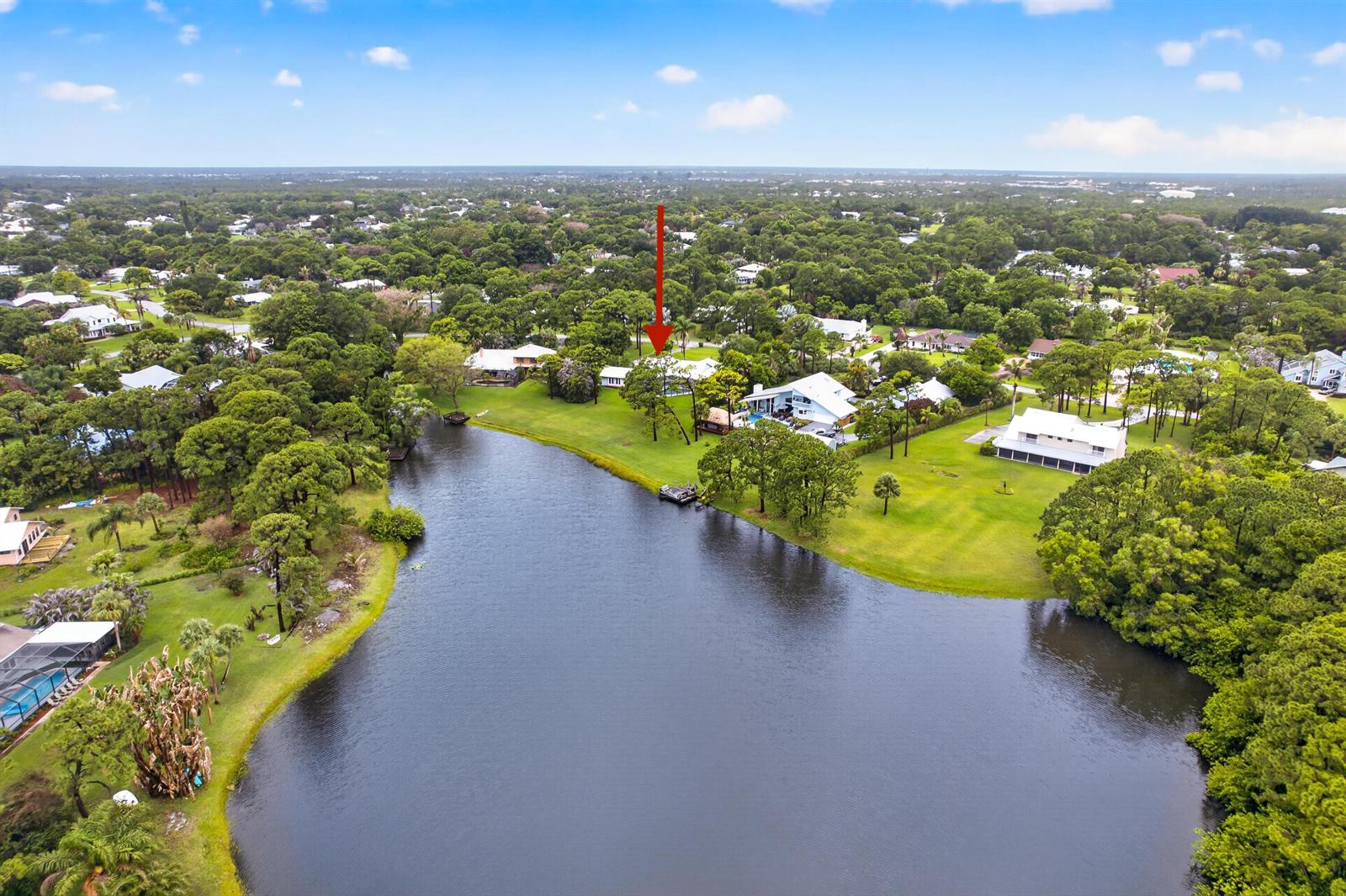 An aerial view shows a waterfront house with a red arrow pointing toward it — 441 NE Town Terrace, Jensen Beach FL 34957, JENSEN BEACH, FL