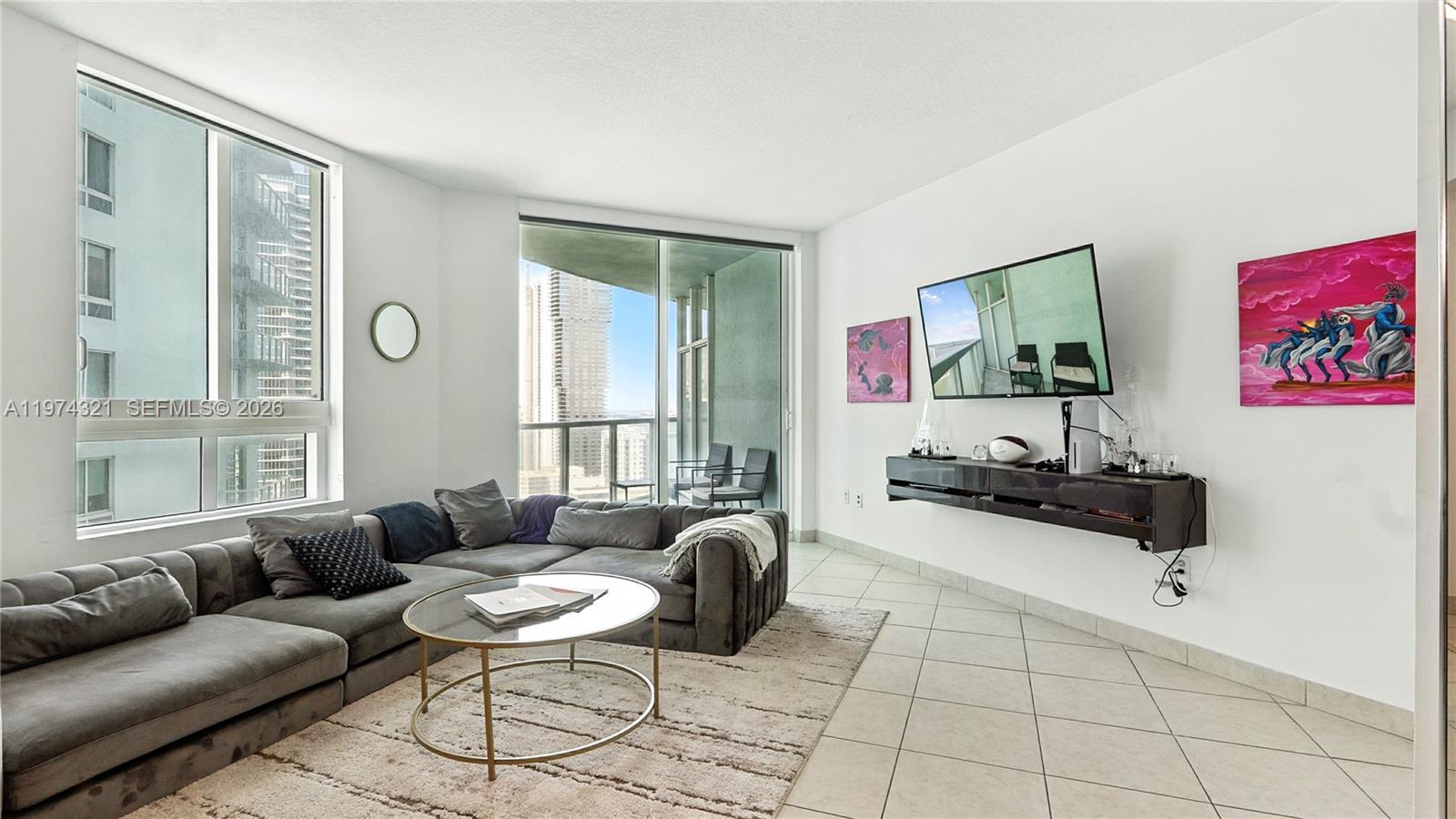 A living room features a grey sectional sofa, a floating console, and floor-to-ceiling windows — 1900 N Bayshore Dr # 2810, Miami FL 33132, MIAMI, FL