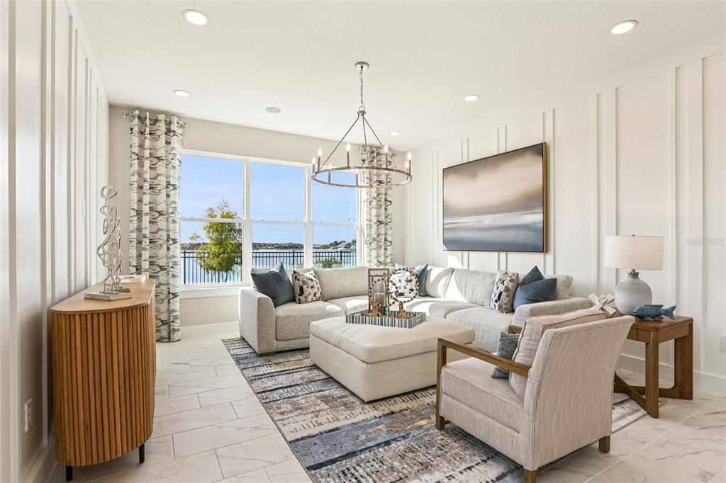 A living room features a sectional sofa, an ottoman, a chandelier, and a water view — 31515 SPANISH MISSION ROAD, SAN ANTONIO, FL