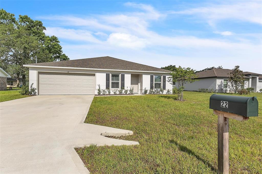 A single-story house with a white exterior, a two-car garage, and a green mailbox — 22 ROUND TREE DRIVE, PALM COAST, FL