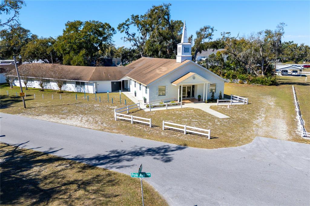 An exterior view of a white church building with a steeple and a brown roof — 6104 POLK AVENUE NW, LAKELAND, FL