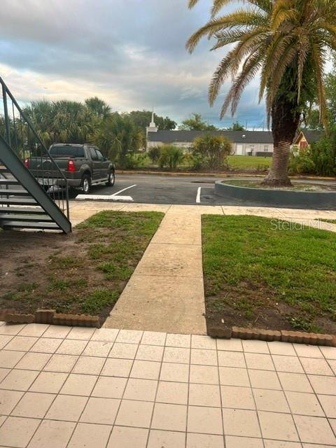 A view from a tiled patio looking toward a parking lot with a pickup truck — 5206 CURRY FORD ROAD UNIT 113, ORLANDO, FL