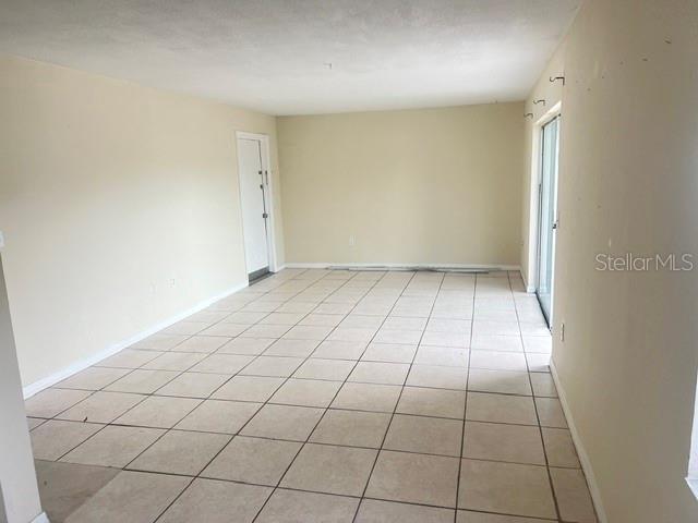 An empty room with beige walls and light-colored square floor tiles — 5206 CURRY FORD ROAD UNIT 113, ORLANDO, FL