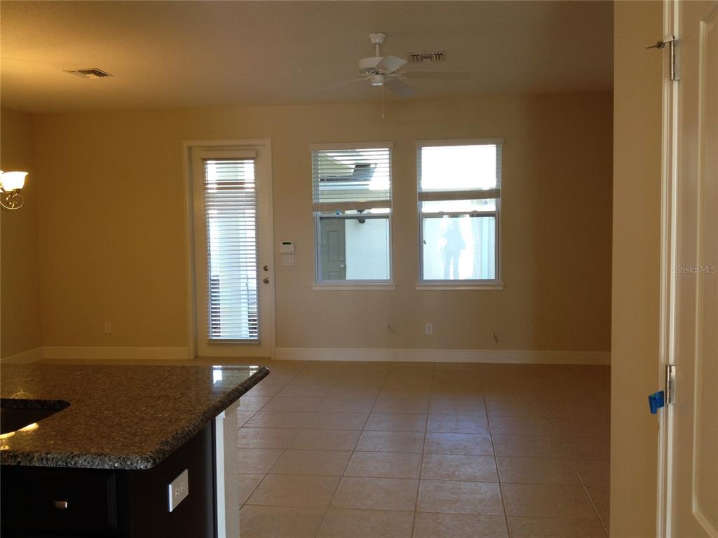 A room with tile flooring, a ceiling fan, a glass door, and two windows — 12349 VIA DERNA PLACE, WINDERMERE, FL