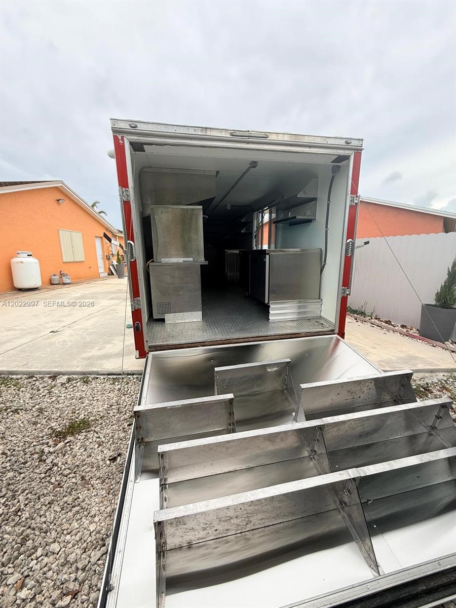 The rear view of a food trailer shows stainless steel equipment and shelving inside — 1234, Homestead FL 1234, HOMESTEAD, FL
