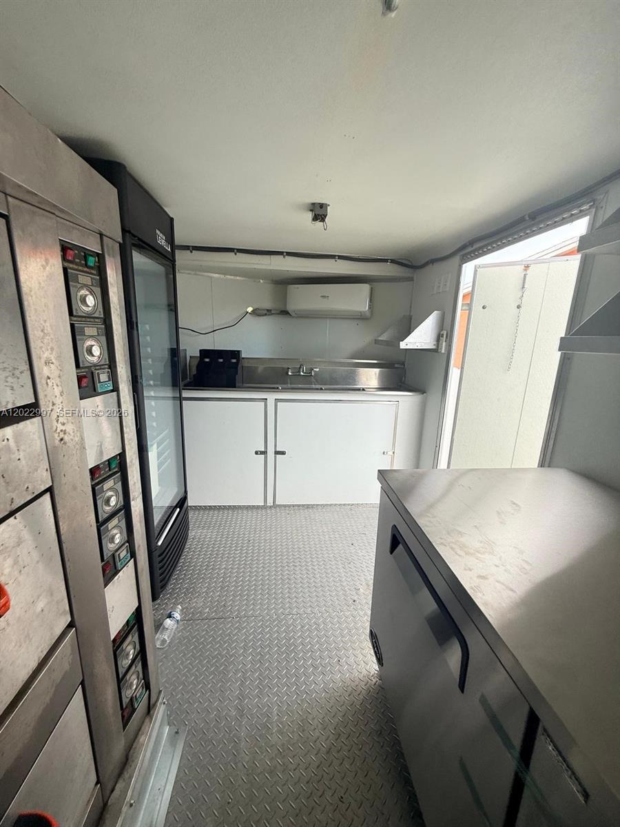 The interior of a food truck features stainless steel counters, a sink, and refrigeration units — 1234, Homestead FL 1234, HOMESTEAD, FL