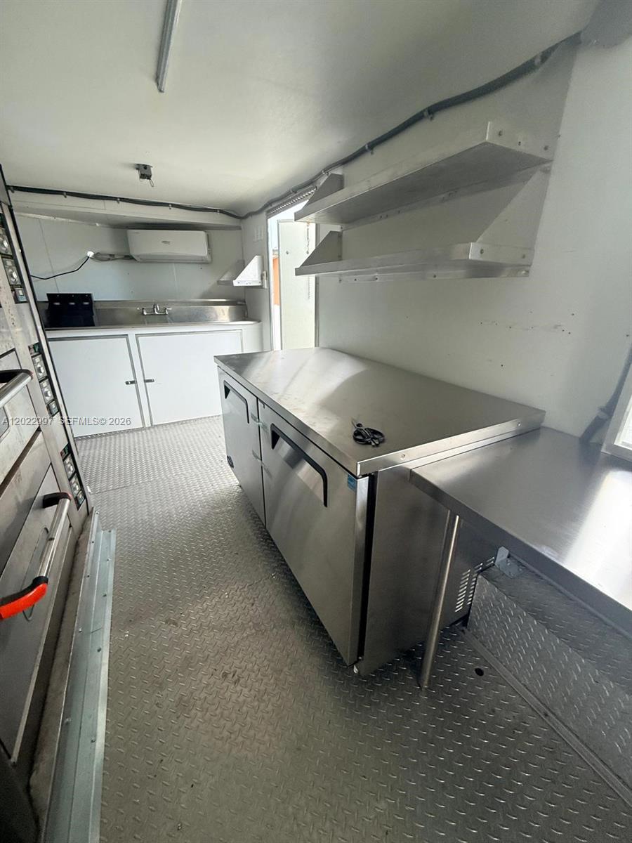 The interior of a food truck features stainless steel counters, shelving, and a sink — 1234, Homestead FL 1234, HOMESTEAD, FL