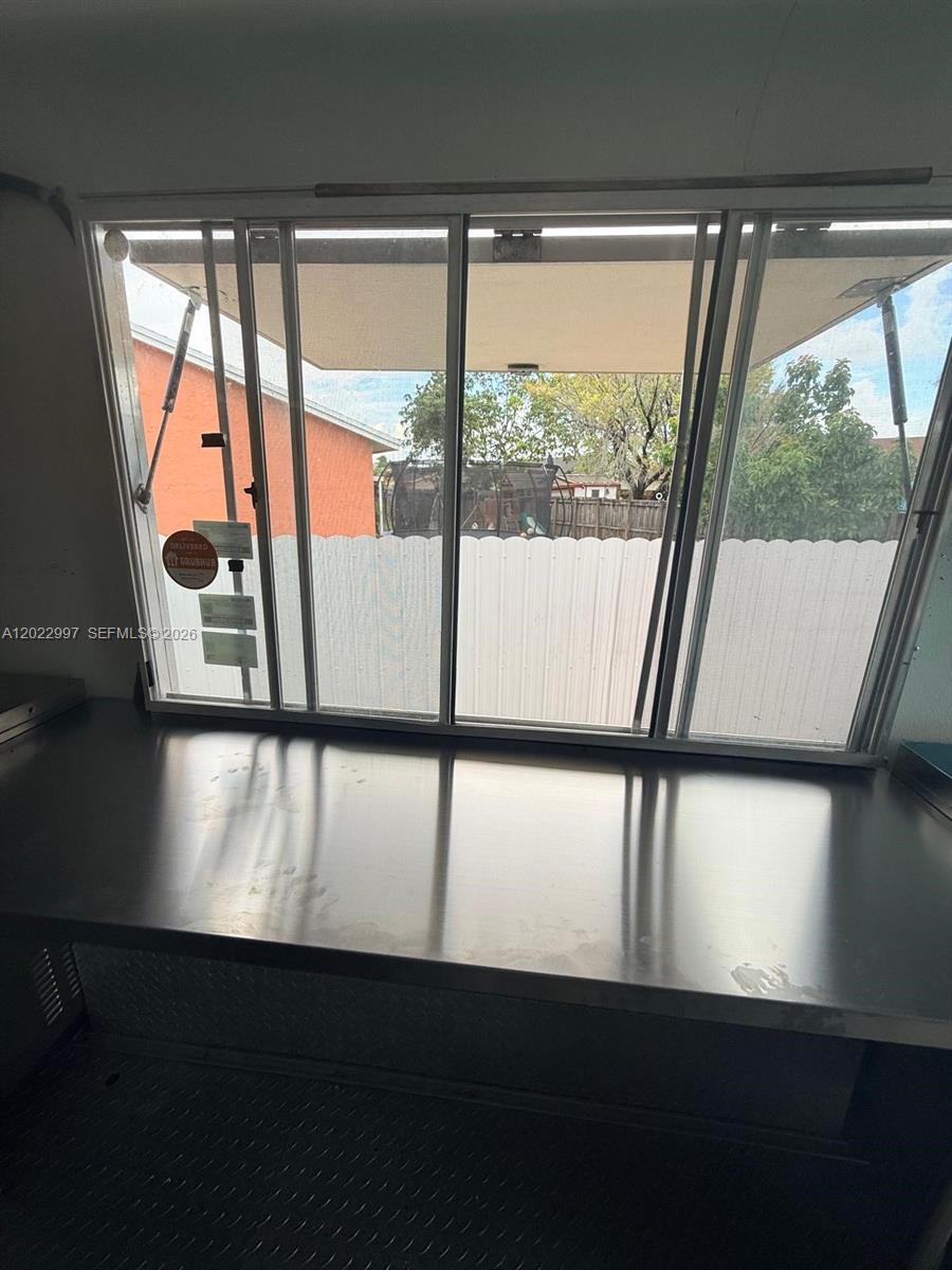 A stainless steel counter sits in front of a large, open service window — 1234, Homestead FL 1234, HOMESTEAD, FL