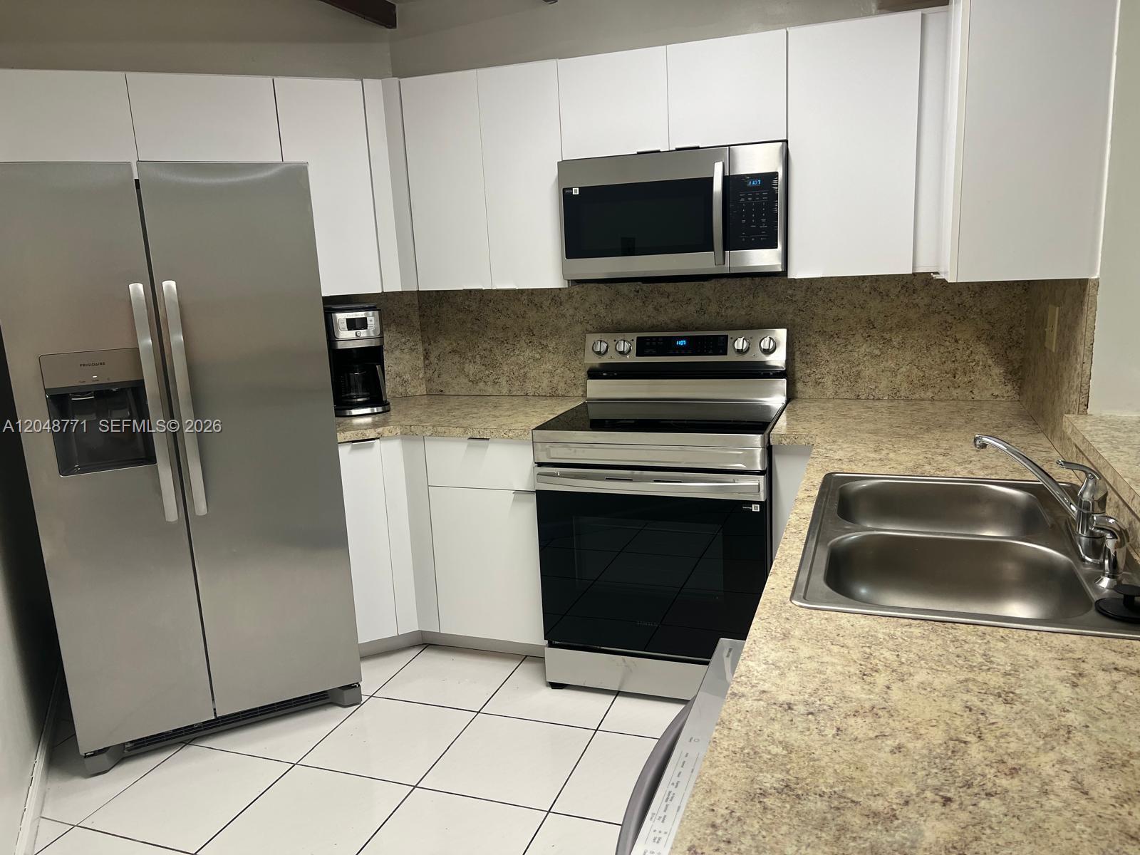 A kitchen features white cabinets, stainless steel appliances, and tan speckled countertops — 10241 NW 9th St Cir # 5, Miami FL 33172, MIAMI, FL