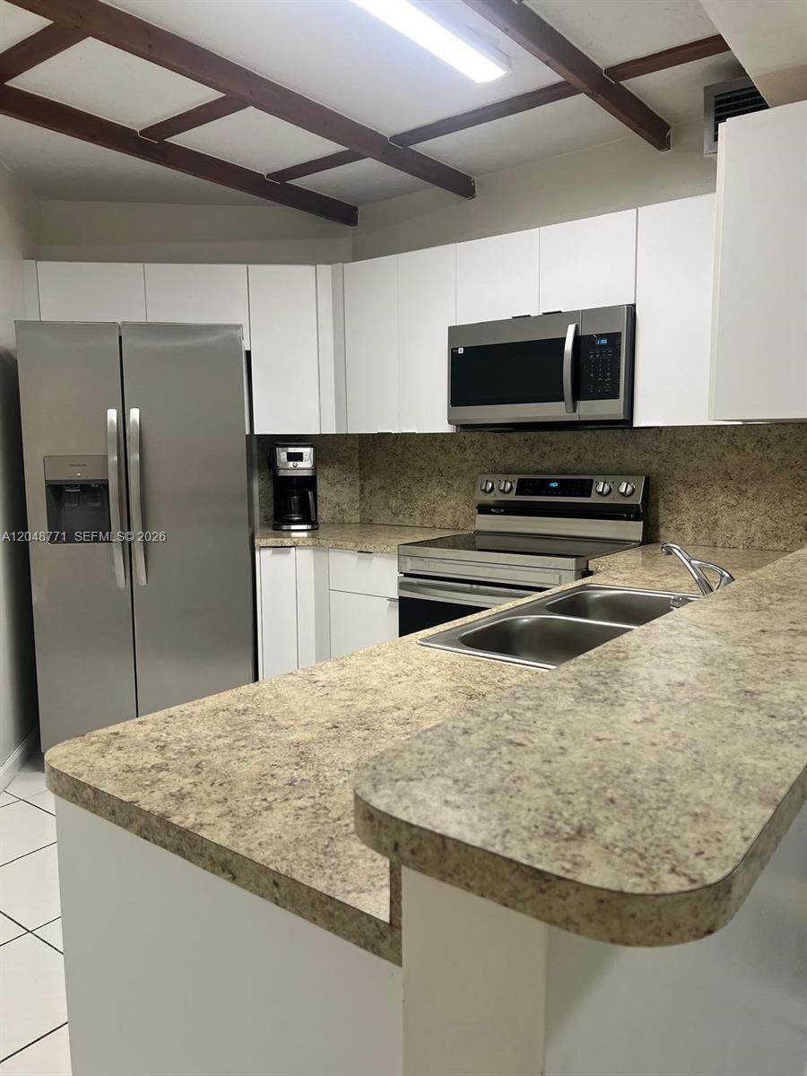 A kitchen features white cabinets, stainless steel appliances, and a speckled laminate countertop — 10241 NW 9th St Cir # 5, Miami FL 33172, MIAMI, FL