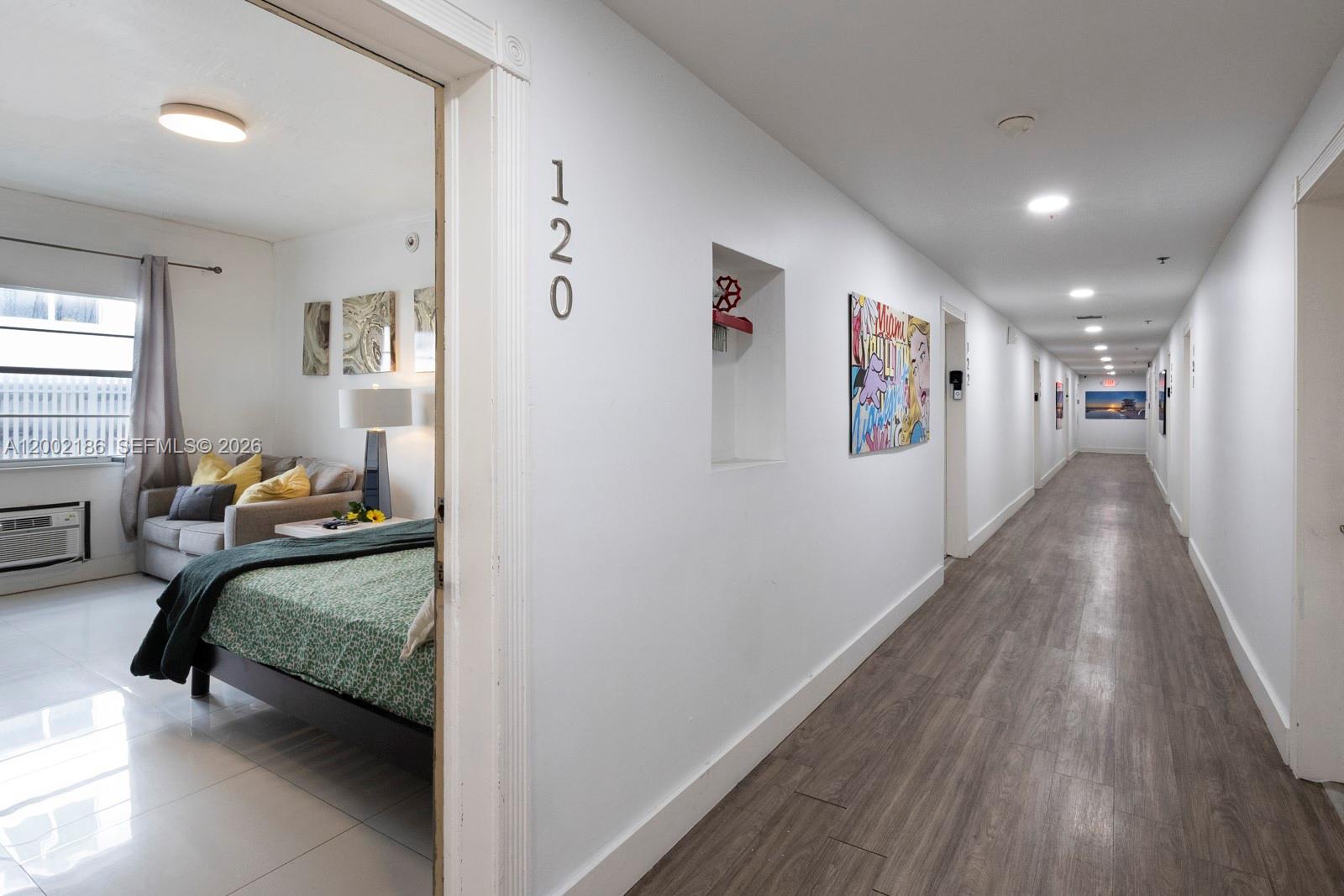 A view from a hallway into a bedroom with a bed and a small sofa — 335 Ocean Dr # 120, Miami Beach FL 33139, MIAMI BEACH, FL