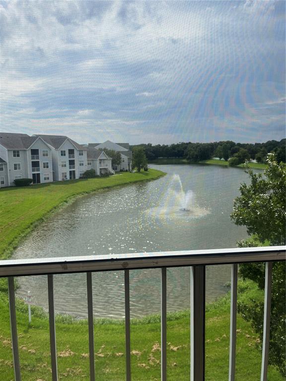 A balcony view overlooking a lake with a fountain and multi-story apartment buildings — 1205 BERMUDA LAKES LANE UNIT 303, KISSIMMEE, FL
