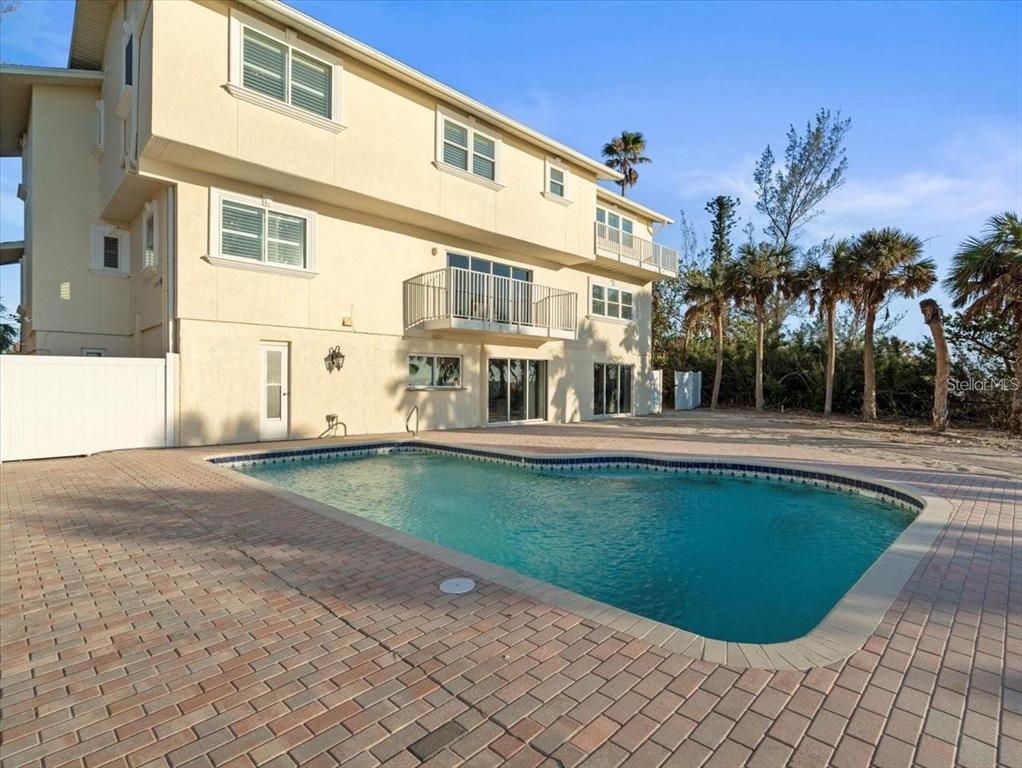 A multi-story house with a swimming pool and brick patio in the backyard — 8030 MANASOTA KEY ROAD, ENGLEWOOD, FL