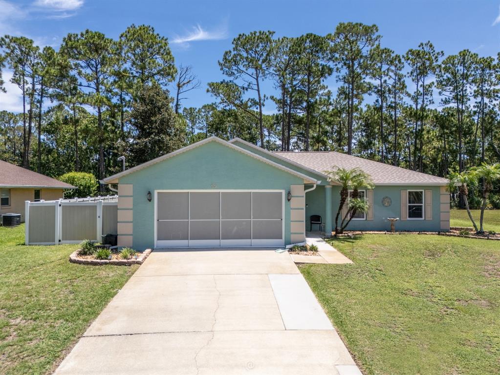 A single-story light green house with a two-car garage and a concrete driveway — 69 PICKERING DRIVE, PALM COAST, FL