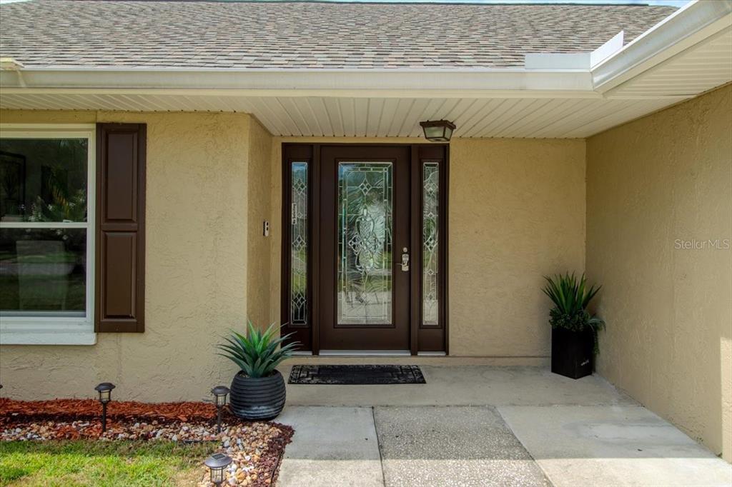 The exterior entrance features a brown front door with glass panels and two sidelights — 4102 W BANK AVENUE, TAMPA, FL