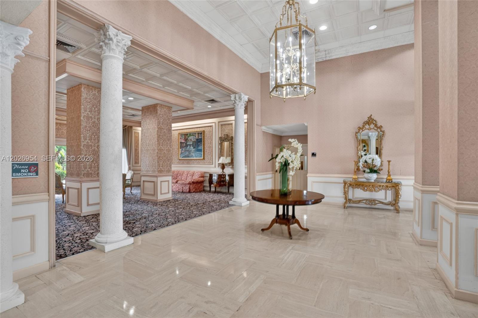 A formal lobby features marble floors, Corinthian columns, a chandelier, and a central round table — 2500 Parkview Dr # 1717, Hallandale Beach FL 33009, HALLANDALE BEACH, FL