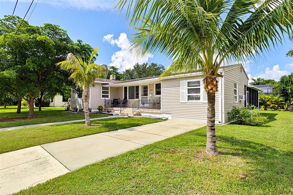 A single-story house with light-colored siding, a concrete driveway, and two palm trees in front — 315 DURRANCE STREET, PUNTA GORDA, FL